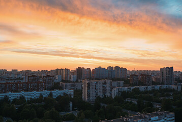 Sunset over urban landscape with vibrant colors illuminating buildings in city skyline