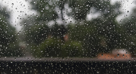 Obraz premium Rainy Window with Water Droplets and Blurred Outdoor Scene