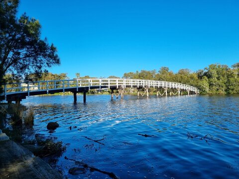 Budgewoi footbridge, over a creek to an island. White railings and wooden boards. Taken at Mackenzie Park, Budgewoi New South Wales Australia