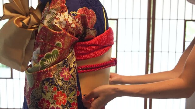 着物の着付けをする女性