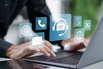 Customer service concept. Support, assistance, call center. Businessman using laptop with contact us icon on virtual screen.