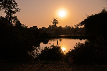 Tranquil Evening Sunset Over a Riverside Landscape with Serene Reflections