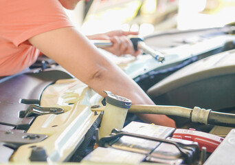 Close up technician hands at work repair car in garage at house holiday. Person activity family home for concept mechanical, transportation, working family. Mothers at home. Technician fix vehicle 