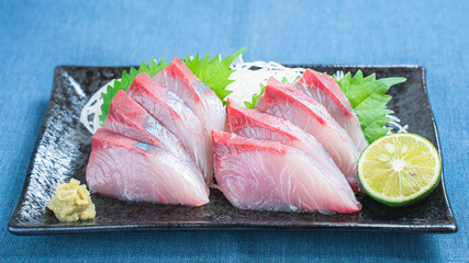 ハマチの刺身と大根のつま、すだちを添えた和食料理
