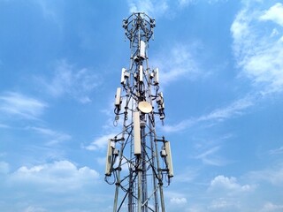 Telecommunication tower with antennas for 5G mobile network against blue sky. Cell tower with antennas for wireless signal, 5G network, and connectivity.