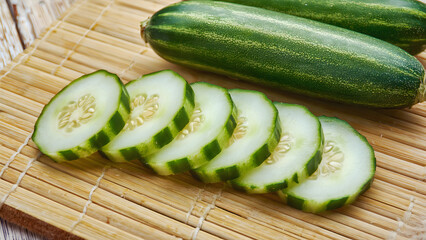 Fresh sliced organic cucumbers on a bamboo mat, healthy eating and vegetarian food concept