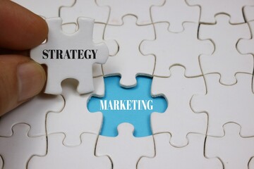 Fototapeta premium Puzzle Concept Depicting Strategy Marketing with Highlighted blue Piece 