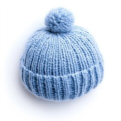 A light-blue knitted baby hat with a large pom-pom sits atop a white background