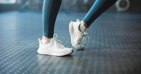 Warm up, shoes and woman in gym, fitness and joint movement with training, wellness and routine. Closeup, sneakers and person in health club, stretching and workout with challenge and exercise