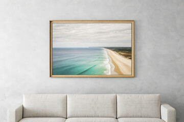 Framed aerial photograph of sandy beach with turquoise water hangs above a white couch