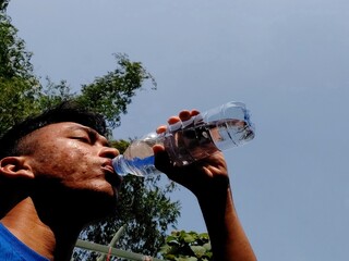 man asia drinking water from bottle