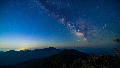 Fototapeta premium Panoramic night view of mountains under a vibrant Milky Way
