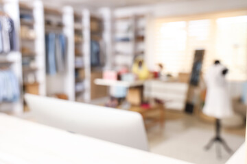 Blurred view of boutique with stylish clothes, mannequin and mirror