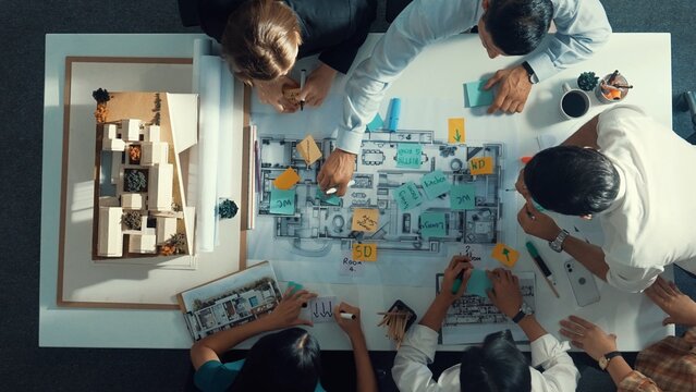 Top aerial view of project manager or civil engineer writing at blueprint and planning building design. Aerial view of architect working together at meeting table with document placed. Alimentation.