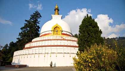 White stupa with decorative details, surrounded by greenery