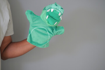 Fun green dinosaur puppet in playful hand performance
