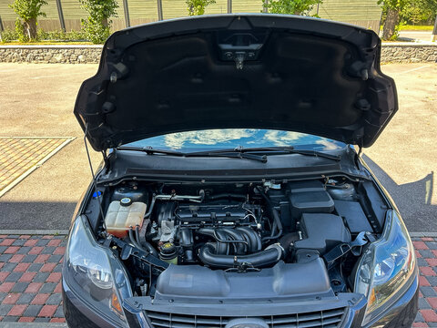 An InDepth Detailed View of a Car Engine with the Hood Open, Skillfully Showcasing the Complex Internal Mechanisms, Components, and Various Functional Parts Within the Engine Compartment