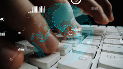 Close-up image of hands skillfully typing on a modern keyboard, enhanced with a digital overlay of a world map, symbolizing technology and global connectivity. Xenic