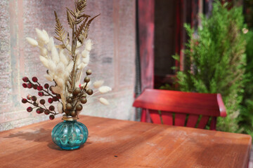 Elegant floral arrangement on rustic wooden table outdoors