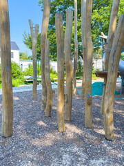 Fototapeta premium NatureInspired Playground A Play Area Designed with Sturdy Wooden Posts and a Safe, Soft Gravel Surface for Children to Enjoy, Encouraging Outdoor Recreation and Exercise in a Beautiful Landscape