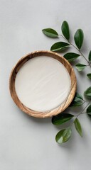Light cream in wooden bowl, leafy sprigs