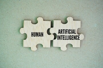 Two puzzles combined with the words human vs. artificial intelligence. The balance between humans and AI. Create art generate content impact.