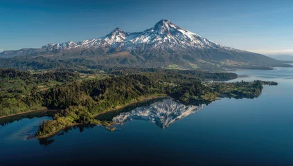 Keuken achterwand Reflectie Aerial view of snow-capped volcanoes reflected in a tranquil lake. Lush greenery surrounds the shoreline  © Harshu