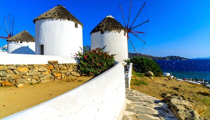 Coastal white windmills with thatched roofs
