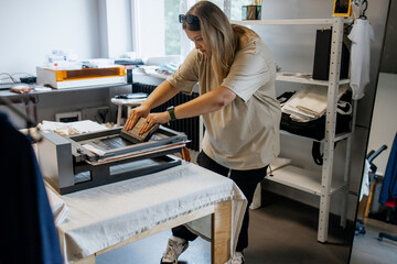 Woman Printing on Fabric with Silk Screen Machine in Modern Workshop &ndash; DIY Textile Design Process