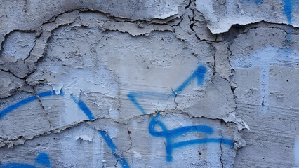Cracked Concrete Wall with Blue Graffiti Urban Decay Texture Background
