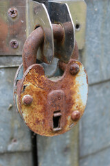 Old rusty padlock on metal surface. Vintage lock symbolizing security, protection, safety, vulnerability, privacy, strength, weakness, retro style, and the passage of time in conceptual design.