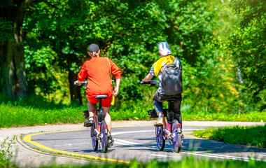 Obraz premium Cyclists ride on the bike path in the city Park 