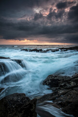 Obraz premium Lorient Morbihan Dark storm clouds over powerful waves rushing against rocks.