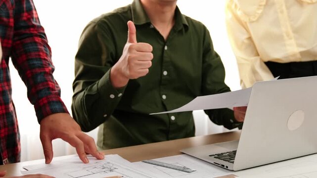 Safety engineer praising skilled architect success design building blueprint project on laptop with architectural document and measurement tool scatter around at modern office. Closeup. Delineation.