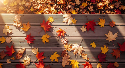 Fototapeta premium Autumn leaves scattered on a wooden surface with a pile of leaves in the background in soft sunlight ai generated
