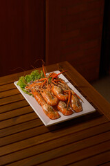 Grilled Shrimp (Goong Pao). Freshly grilled jumbo shrimps, a popular Thai seafood delicacy, served on a white platter with lettuce. Delicious, authentic Thai cuisine from Pattaya.