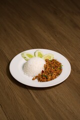 Authentic Thai Stir-Fried Minced Pork with Basil (Pad Krapow Moo Saap) served with Jasmine Rice and Cucumber Slices. A Popular, Spicy & Aromatic Street Food Classic from Thailand.