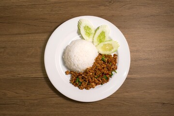 Authentic Thai Stir-Fried Minced Pork with Basil (Pad Krapow Moo Saap) served with Jasmine Rice and Cucumber Slices. A Popular, Spicy & Aromatic Street Food Classic from Thailand.