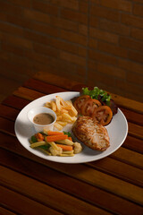 Grilled Chicken Steak Platter. A complete meal with french fries, mixed vegetables, salad, and dipping sauce on a white plate. Hearty Western comfort food for a restaurant menu.