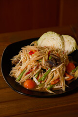 Thai Papaya Salad with Crab and Fermented Fish Sauce, garnished with fresh cabbage wedges. Authentic Som Tum Poo Pla Ra for Thai food enthusiasts and culinary collections.