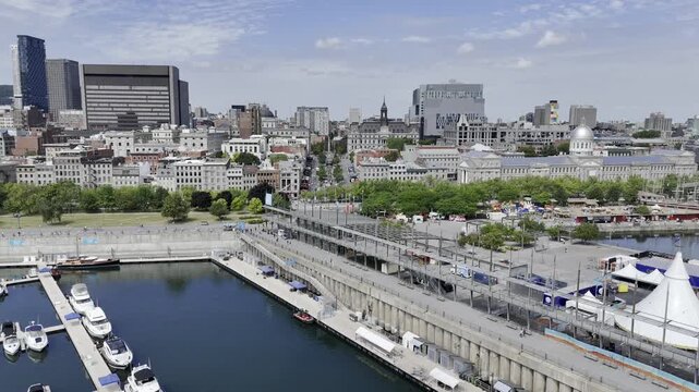 Drone flies west from the St. Lawrence River over the Old Port down Jacques Cartier Street past city hall in Montreal, Quebec, Canada