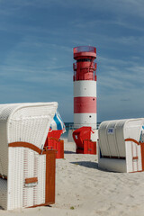 Obraz premium Red and white striped lighthouse and Colorful beach chairs, Helgoland, island Düne, Schleswig-Holstein, Germany, Europe