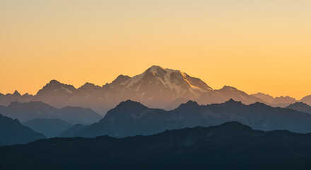 Mountain sunrise landscape with golden light over distant peaks