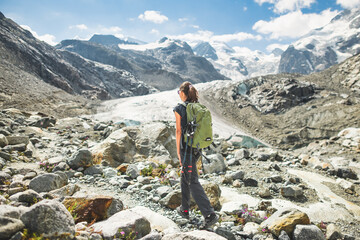Girl walks in the mountains towards a glacier
