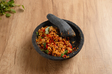 Sambal Tempe served on cobek. Tempe is a traditional food from Indonesia made from soybean. Perfect for recipes, articles or any cooking content.