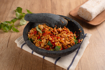 Sambal Tempe served on cobek. Tempe is a traditional food from Indonesia made from soybean. Perfect for recipes, articles or any cooking content.