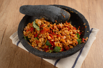 Sambal Tempe served on cobek. Tempe is a traditional food from Indonesia made from soybean. Perfect for recipes, articles or any cooking content.