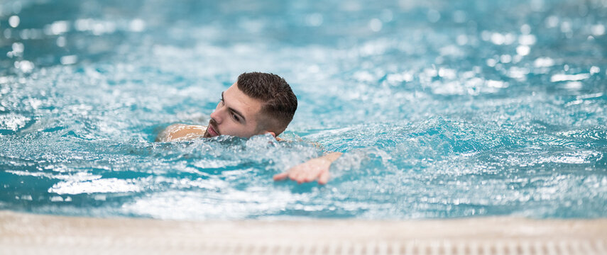 Man doing aquatic therapy or swimming exercises in a professional spa facility indoor pool.