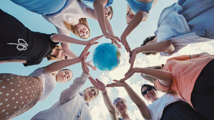 School friends uniting to protect the environment and promote global sustainability by joining hands around a globe