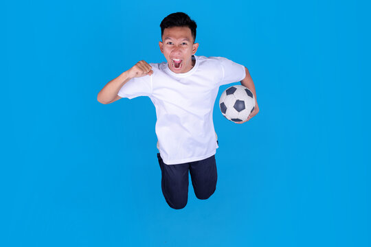 High Angle Of Young Soccer Fan Jumping While Cheering With Soccer Ball Celebrating Victory